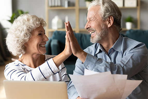 happy senior couple high fiving taxes on retirement income